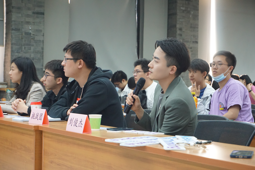 A group of people sitting at a table with microphones and papersDescription automatically generated with low confidence A group of people sitting at a table with microphones and papersDescription automatically generated with low confidence